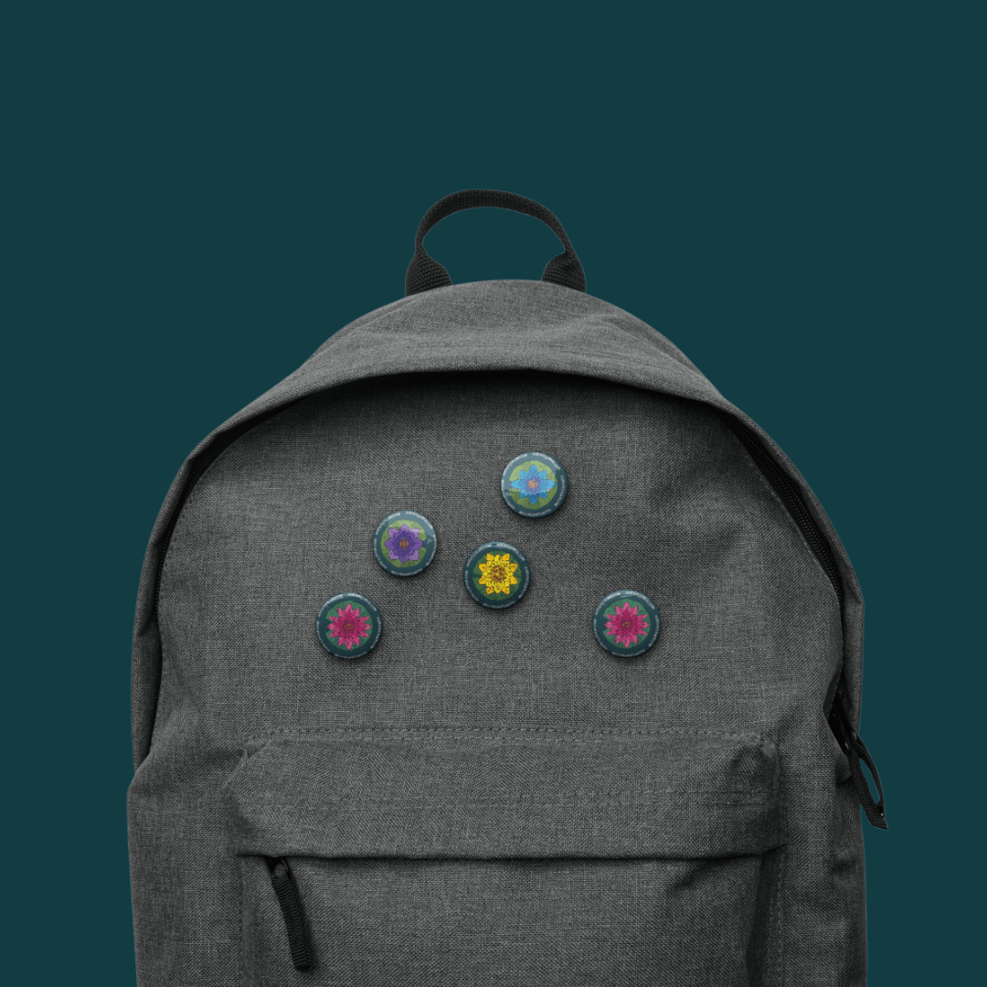 Gray backpack with five colorful mandala buttons on a dark teal background.