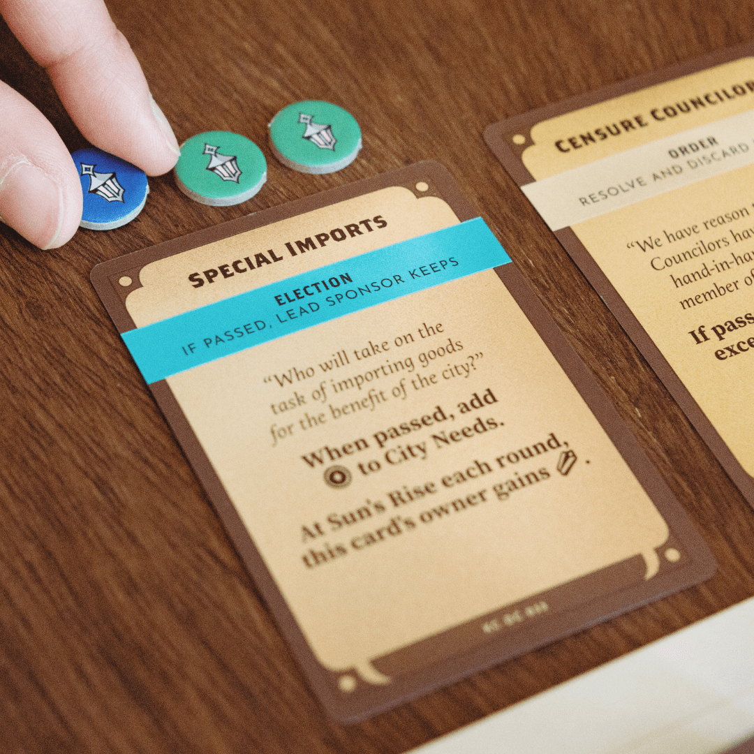 Board game cards and tokens on a wooden table.