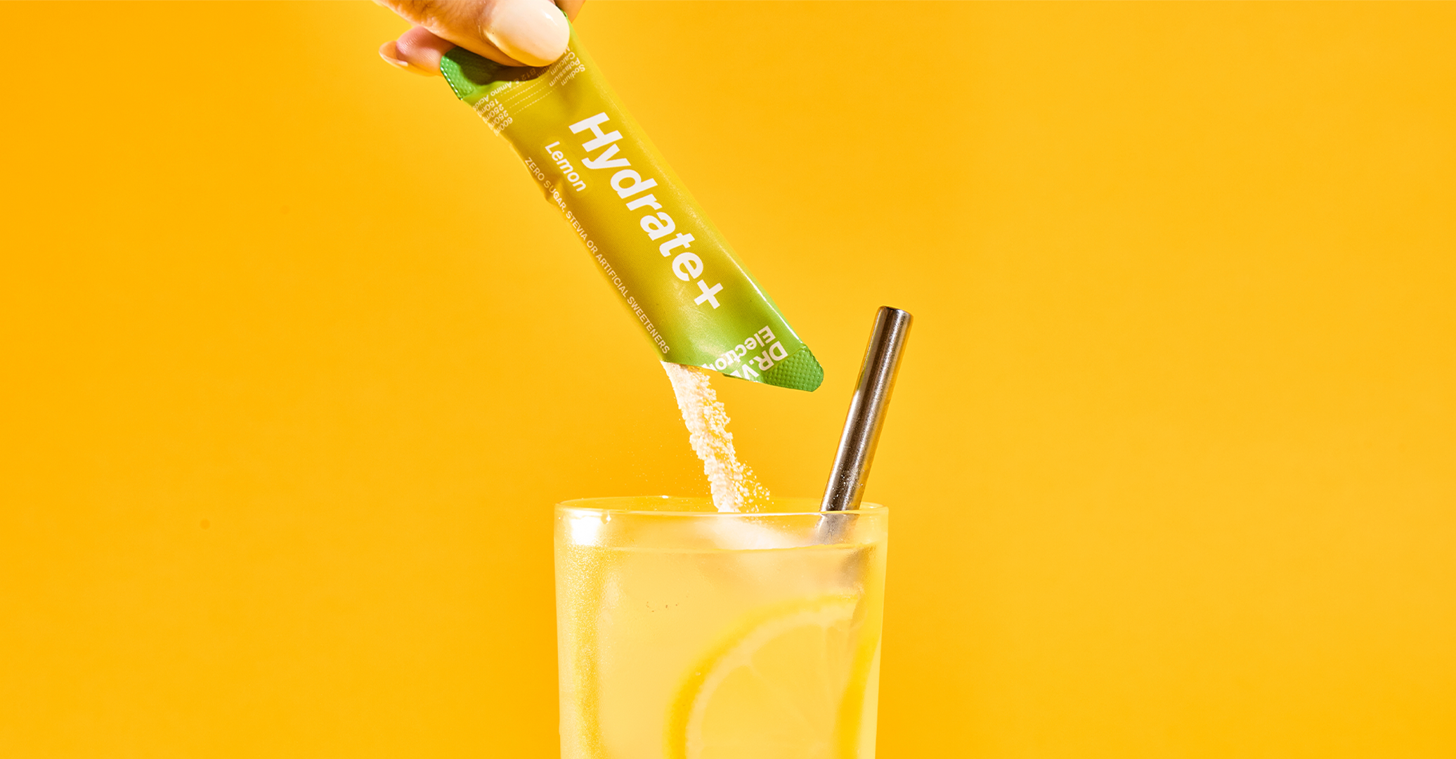 Glass of lemon water with powder poured, yellow background.