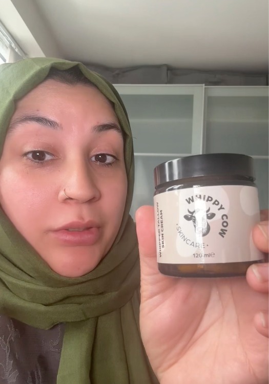 Person holding a jar labeled 'Whippy Cow Skincare'.