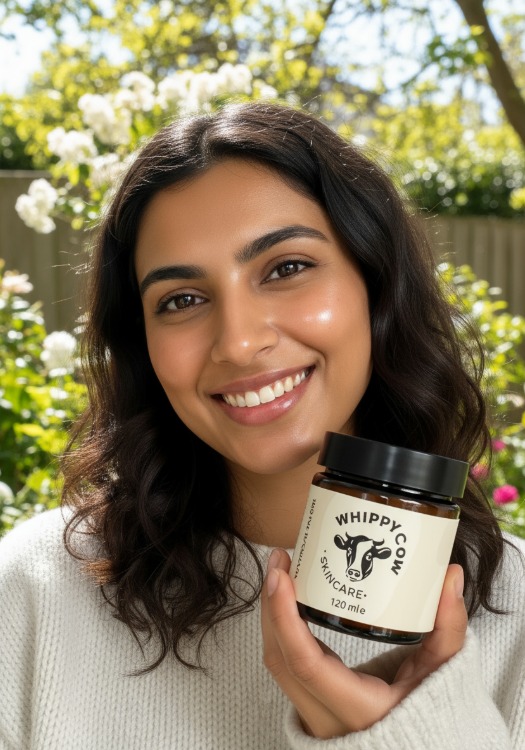 Person holding a jar labeled 'Whippy Cow Skincare' with a cow logo.