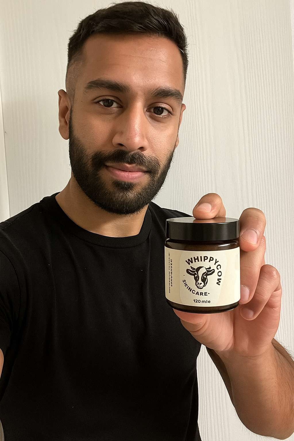 Person holding a jar labeled 'Whippy Cow Skincare' with a cow logo.