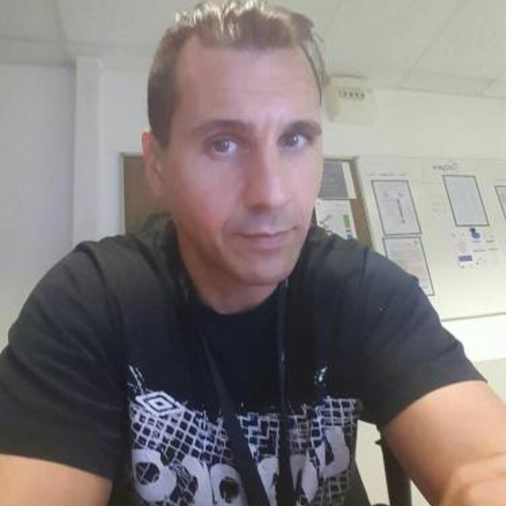 Person in a black shirt sitting in an office environment.