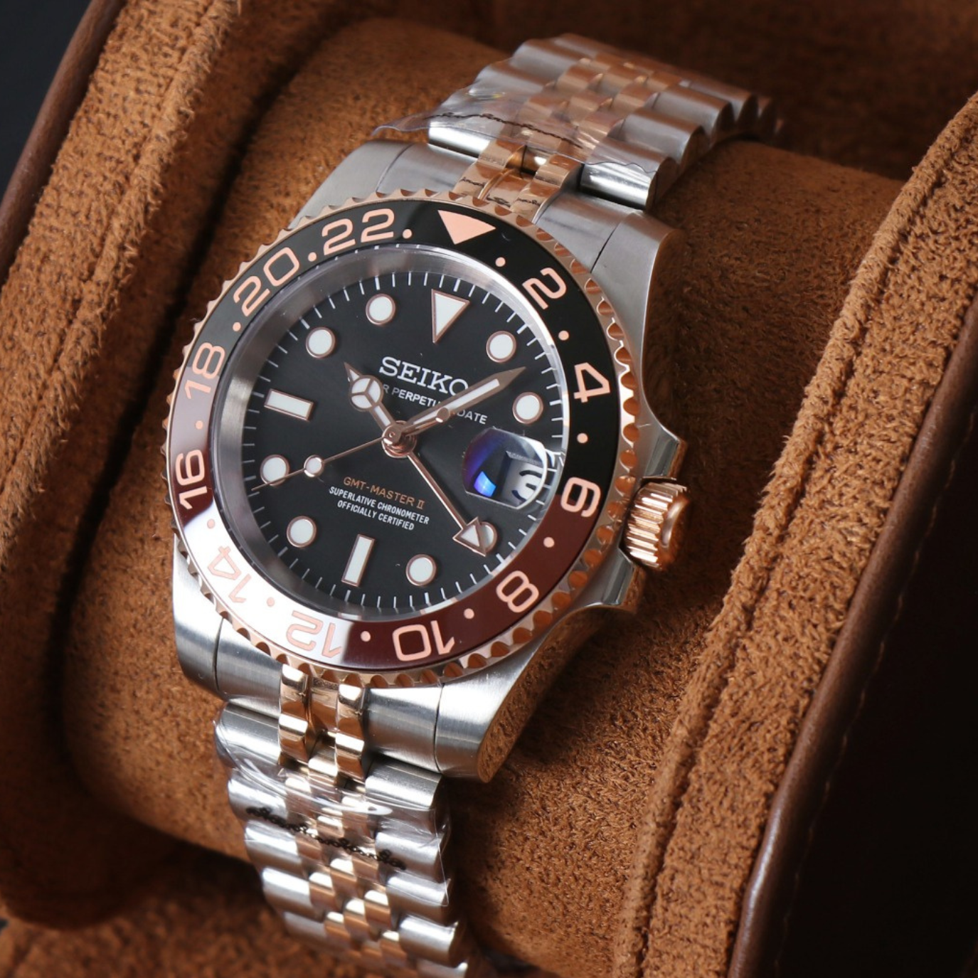 A luxury watch with a two-tone metal band and detailed dial in a leather display case.