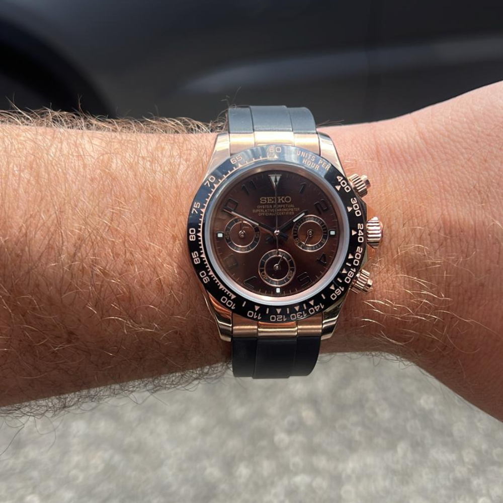 Wrist with a Seiko chronograph watch featuring a black strap and three subdials.