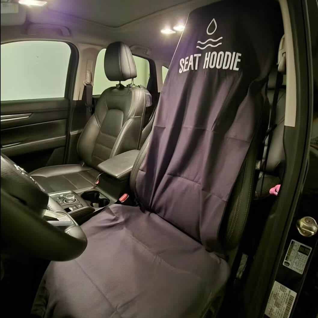 A black waterproof car seat cover with the logo 'Seat Hoodie' on a driver's seat.