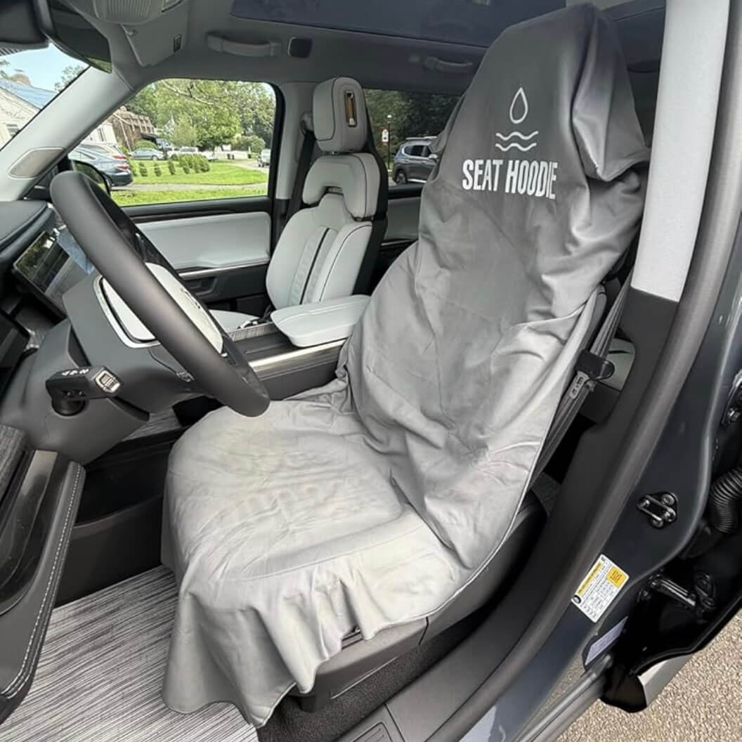 A gray 'Seat Hoodie' waterproof cover protecting the driver's seat inside a modern car.