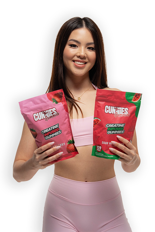 A smiling woman in pink athletic wear holds up two pouches of Creatine Infused Gummies.