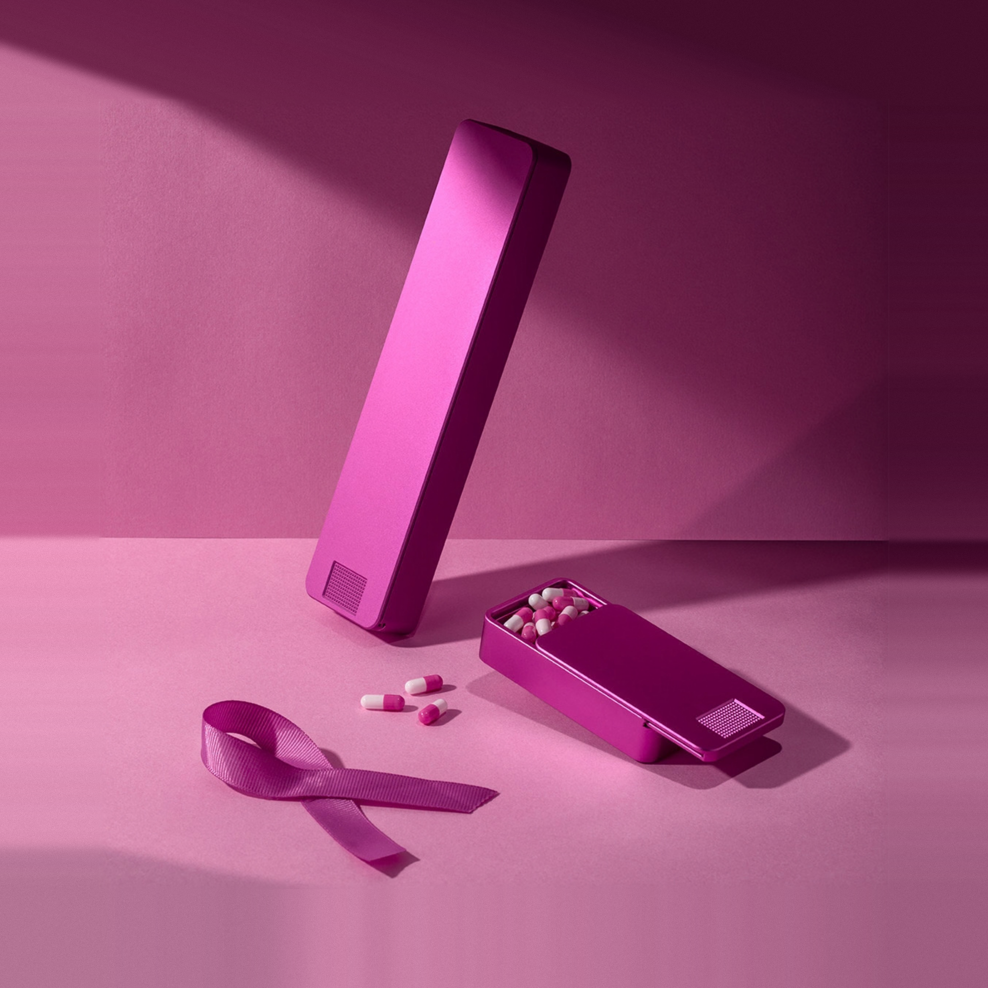 A pink awareness ribbon next to two pink pill cases filled with pink and white capsules.