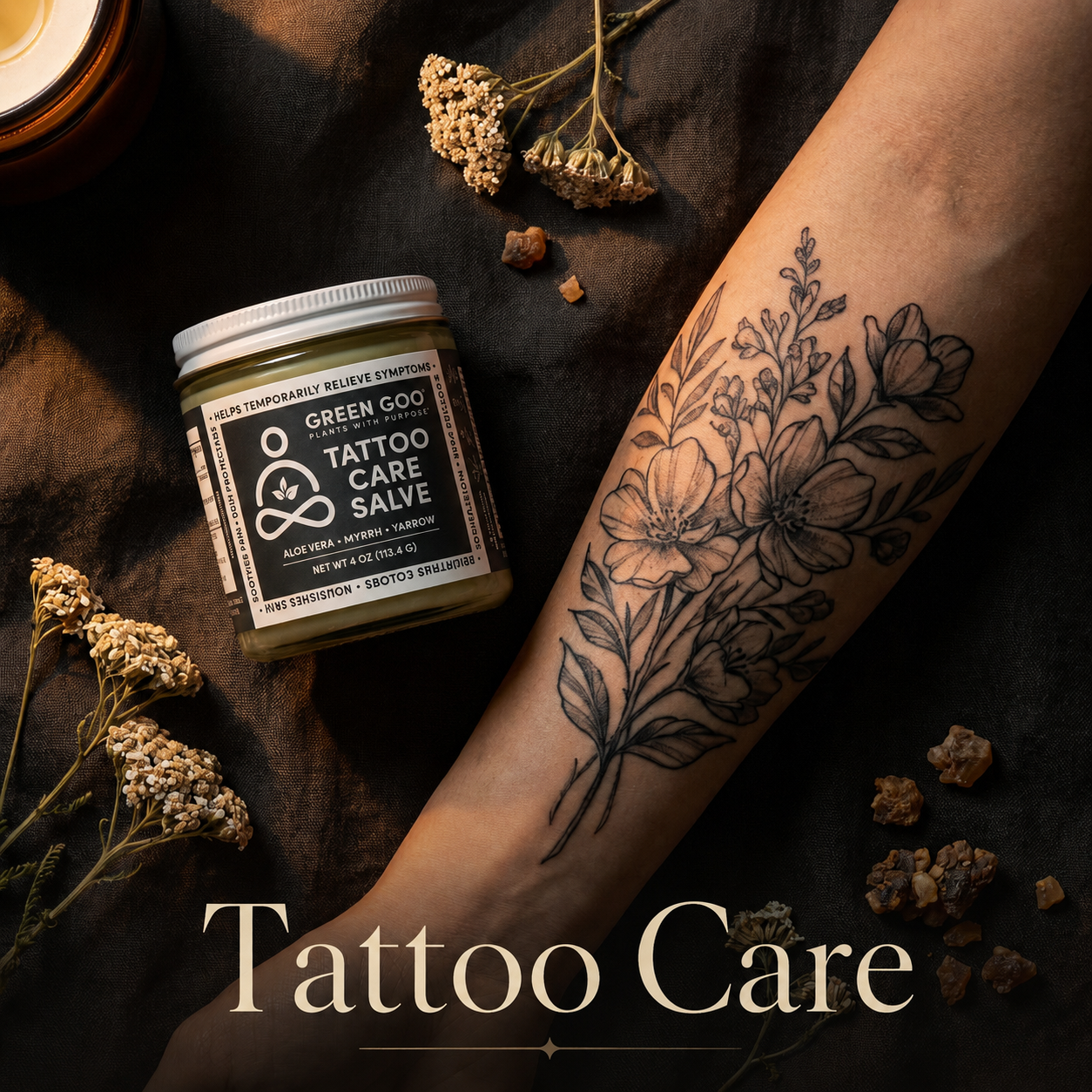 Jar of Tattoo Care near tattooed arm and herbs