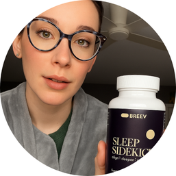 Person holding a bottle labeled 'Breev Sleep Sidekick' with a ceiling fan in the background.