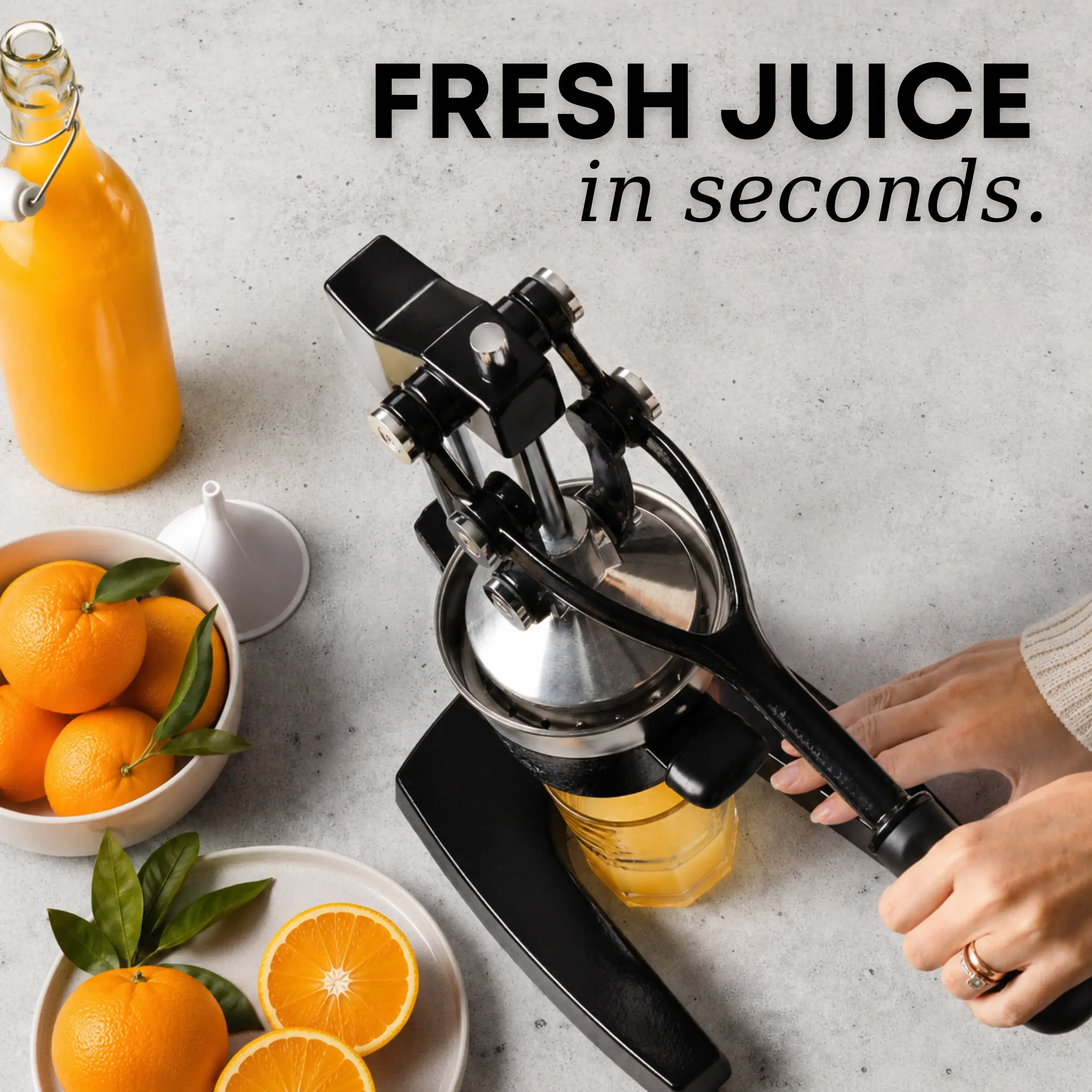 A person uses a black manual press to make fresh orange juice, surrounded by whole and sliced oranges.