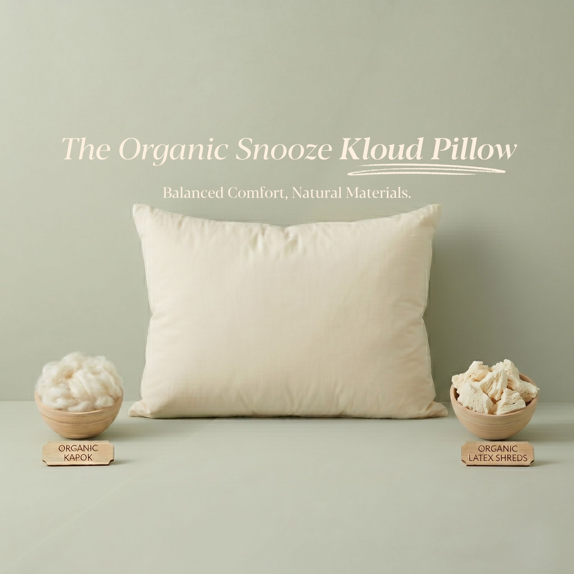 An off-white pillow is displayed with two small bowls showing its organic kapok and latex shred fillings.