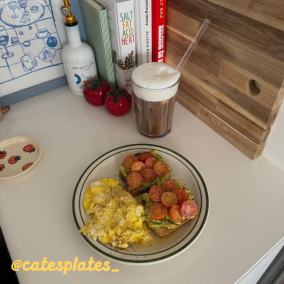 Plate with scrambled eggs, avocado toast, iced coffee, and kitchen decor.