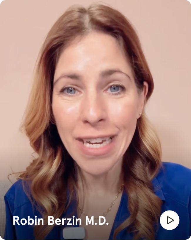 A headshot of a smiling woman, Robin Berzin M.D., with wavy, light-brown hair, wearing a blue shirt.