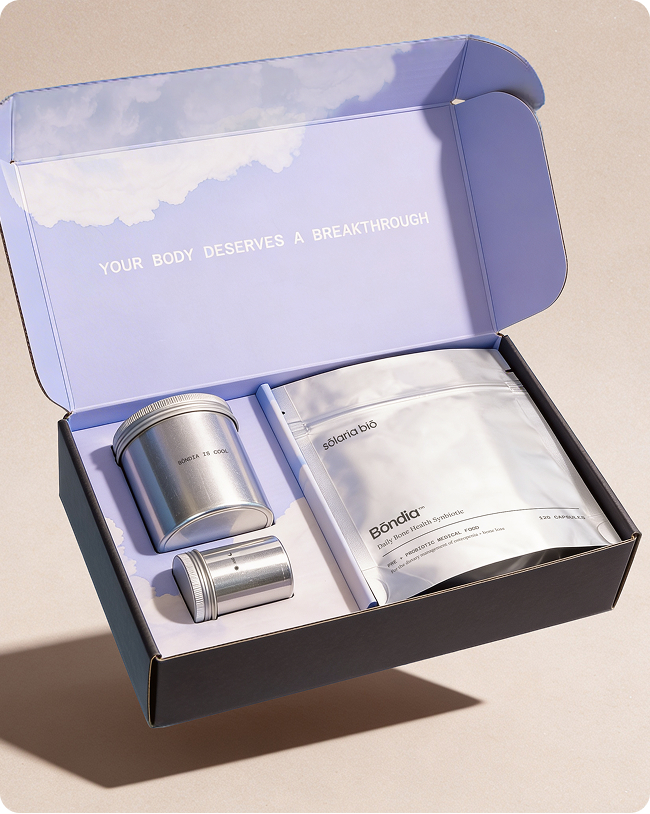 A health product kit in an open box with two silver tins and a white pouch.