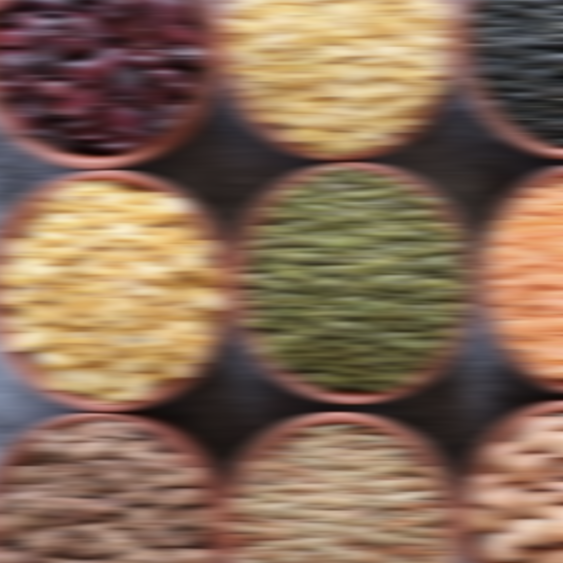 Blurred image of various colorful dried foods in oval bowls.