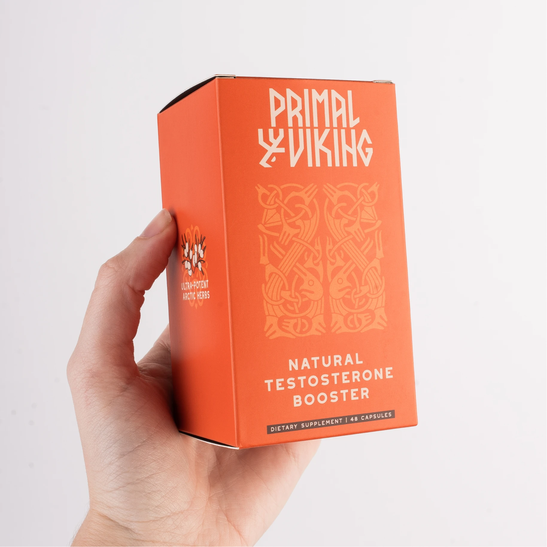 Hand holding an orange box labeled 'Natural Testosterone Booster'.