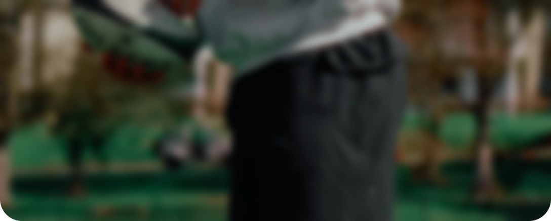 A heavily blurred image of a person's torso against a green and brown background.