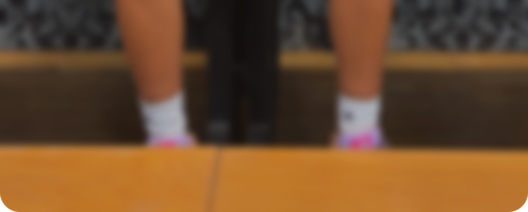 A blurry, low-angle shot of a person's ankles and feet in white socks.
