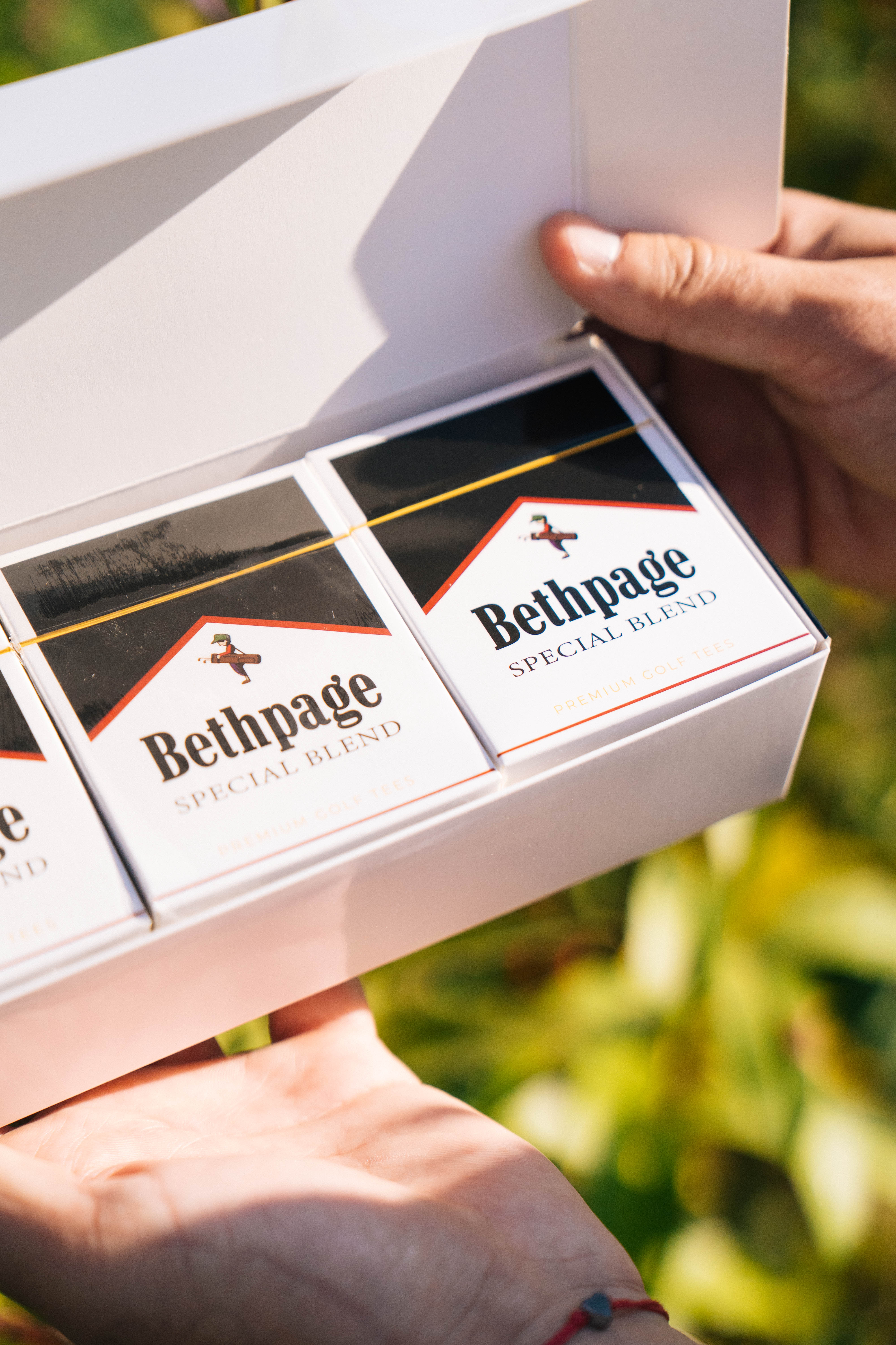 Hand holding a box of Bethpage Special Blend golf tees.