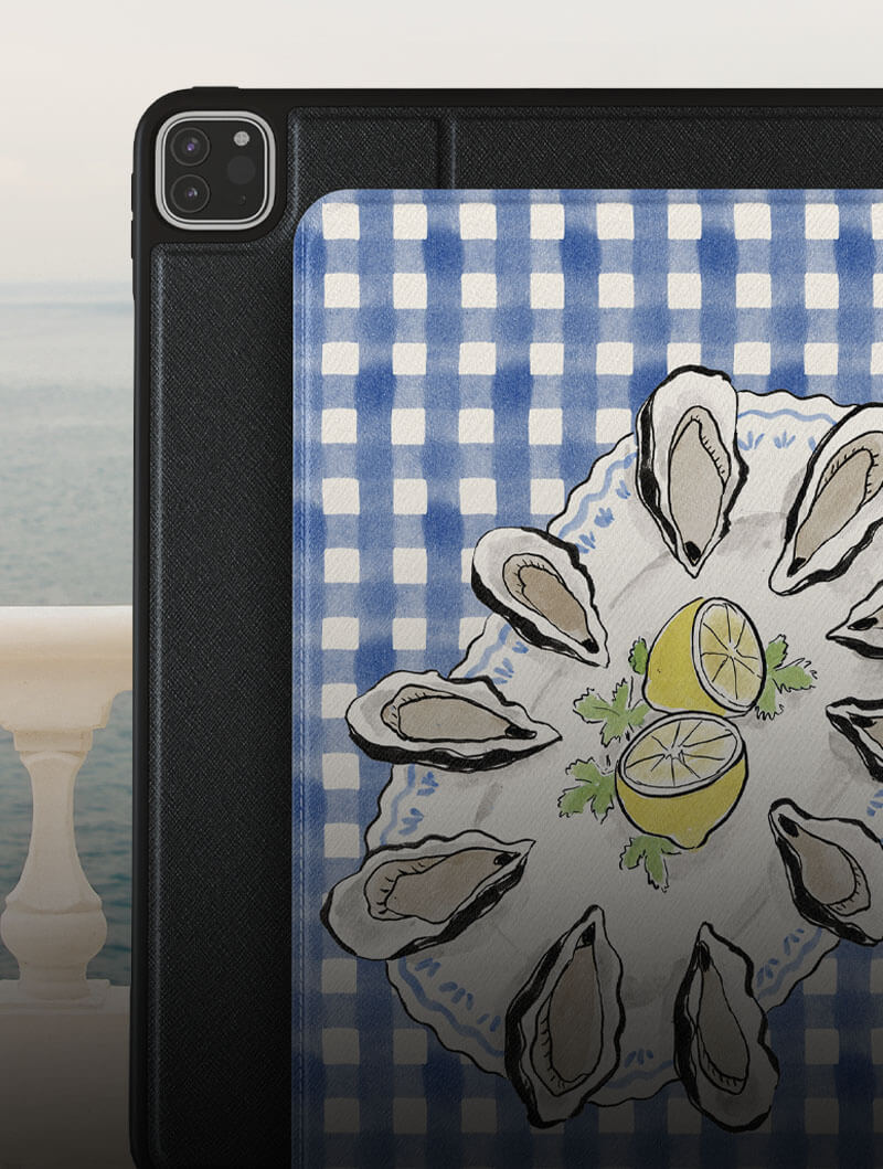 Tablet with a case featuring oysters and lemons on a blue checkered background.