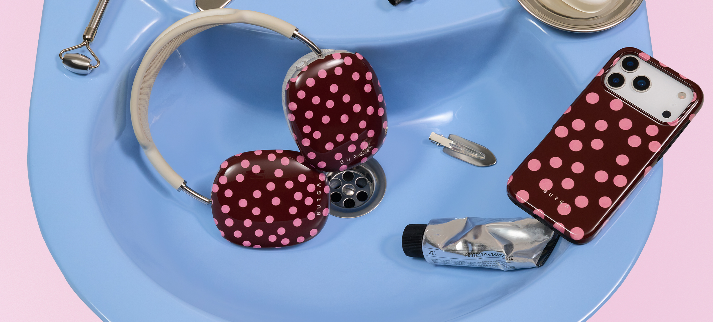 Three patterned phone cases on a silver platter with wax-sealed letters and a heart locket.