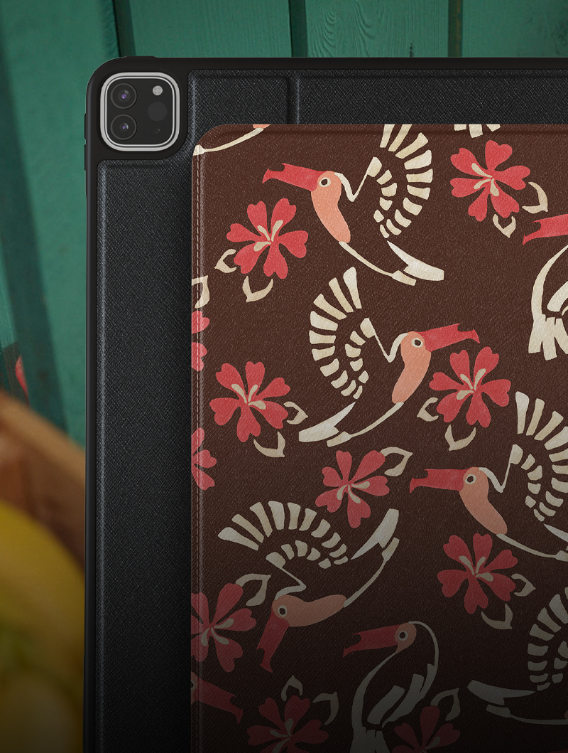 Tablet with floral and bird pattern case on a wooden surface.