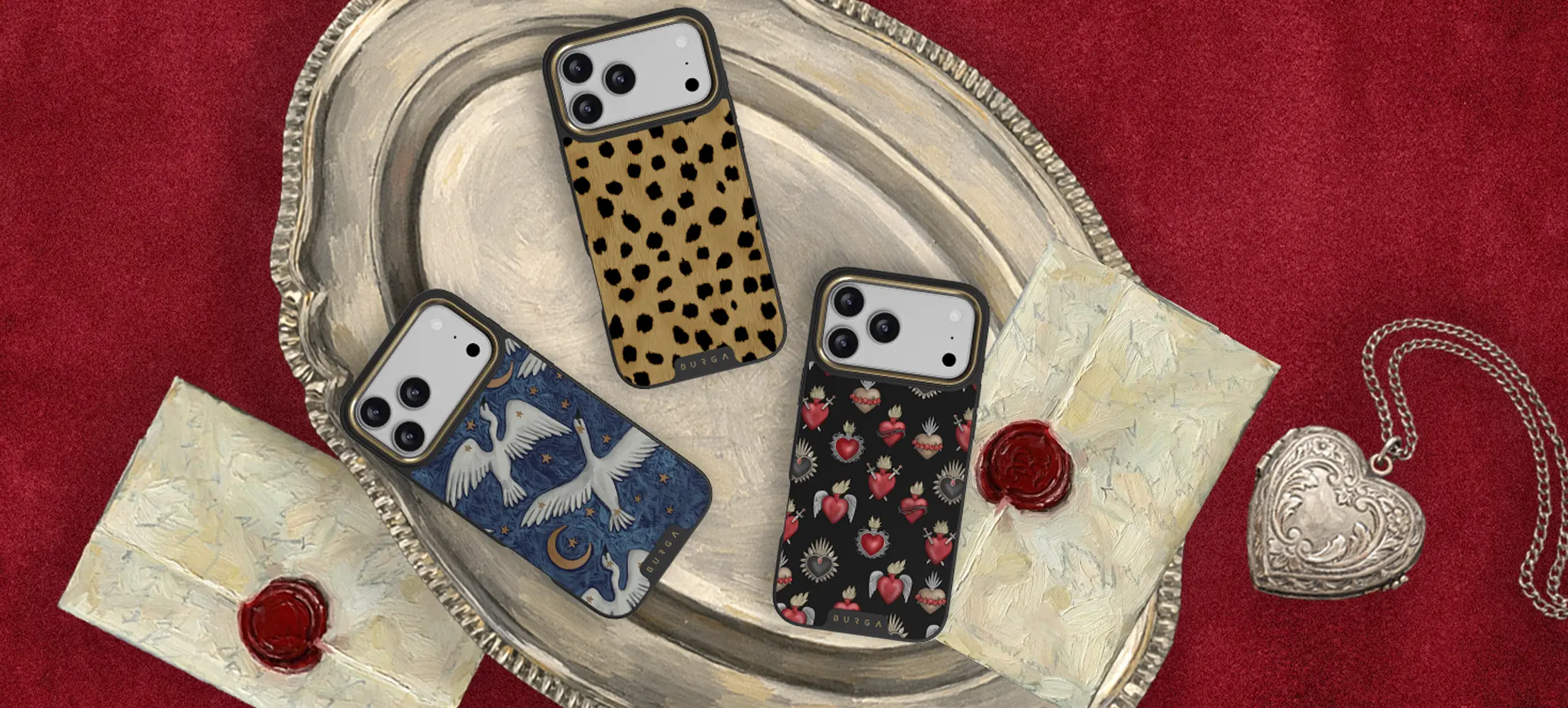 Three patterned phone cases on a silver tray with wax-sealed envelopes and a heart locket.
