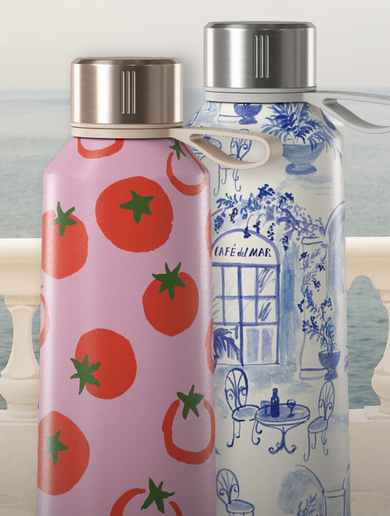 Two decorative bottles with tomato and café designs, against a seaside background.