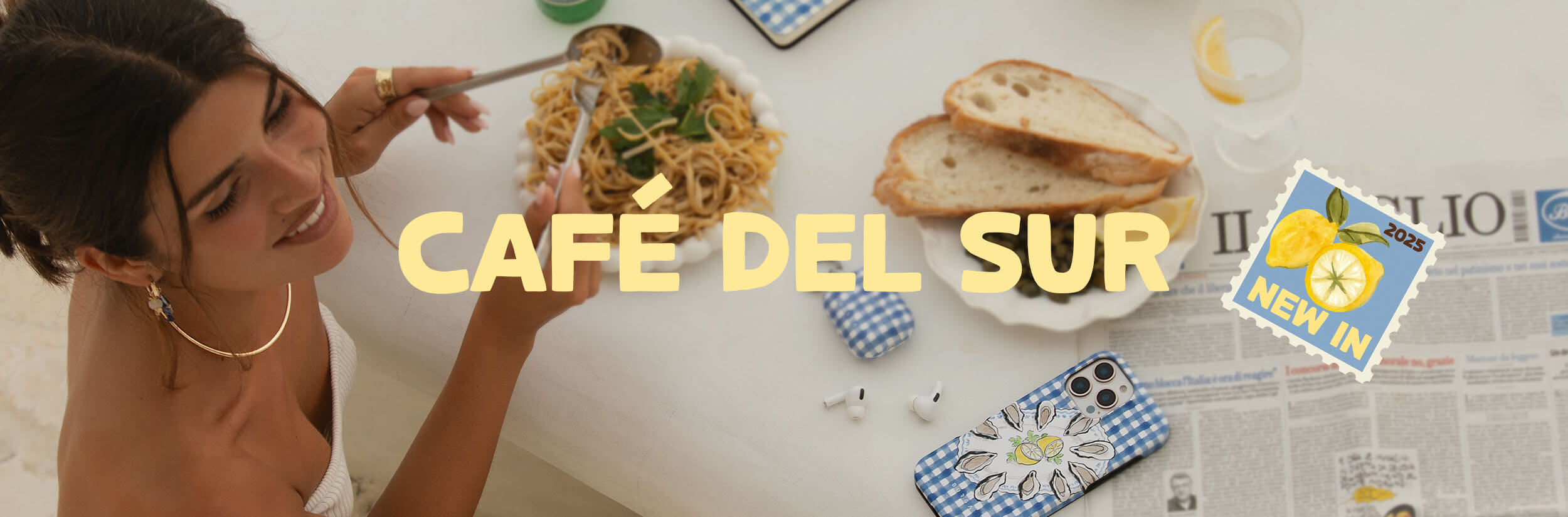 Woman eating pasta at a table with bread, phone, and newspaper.