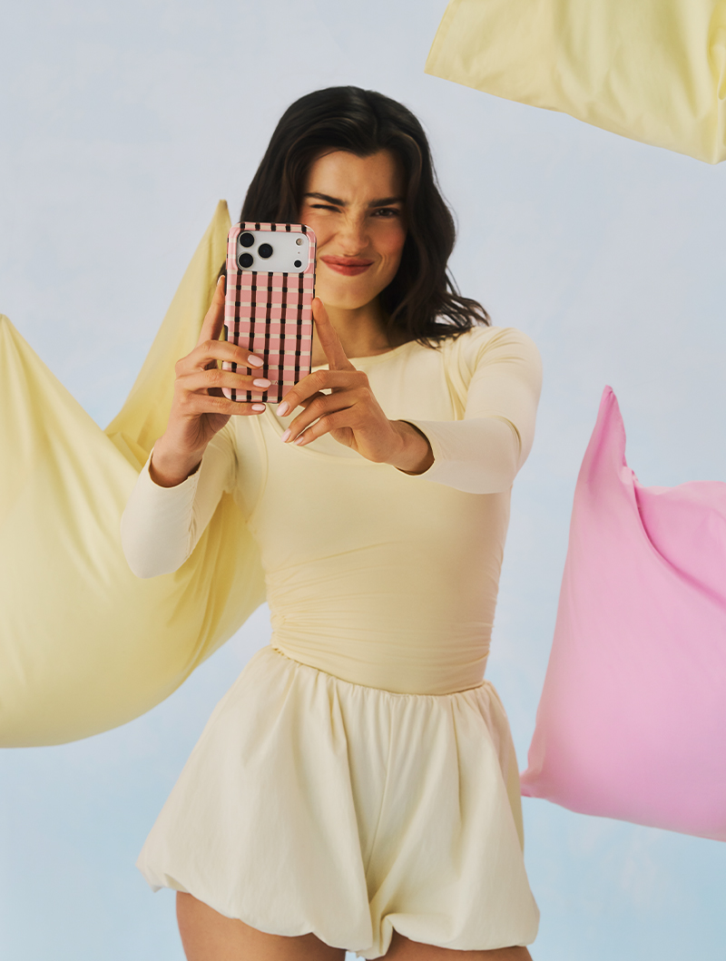 Three patterned phone cases on a silver platter with wax-sealed letters and a heart locket.