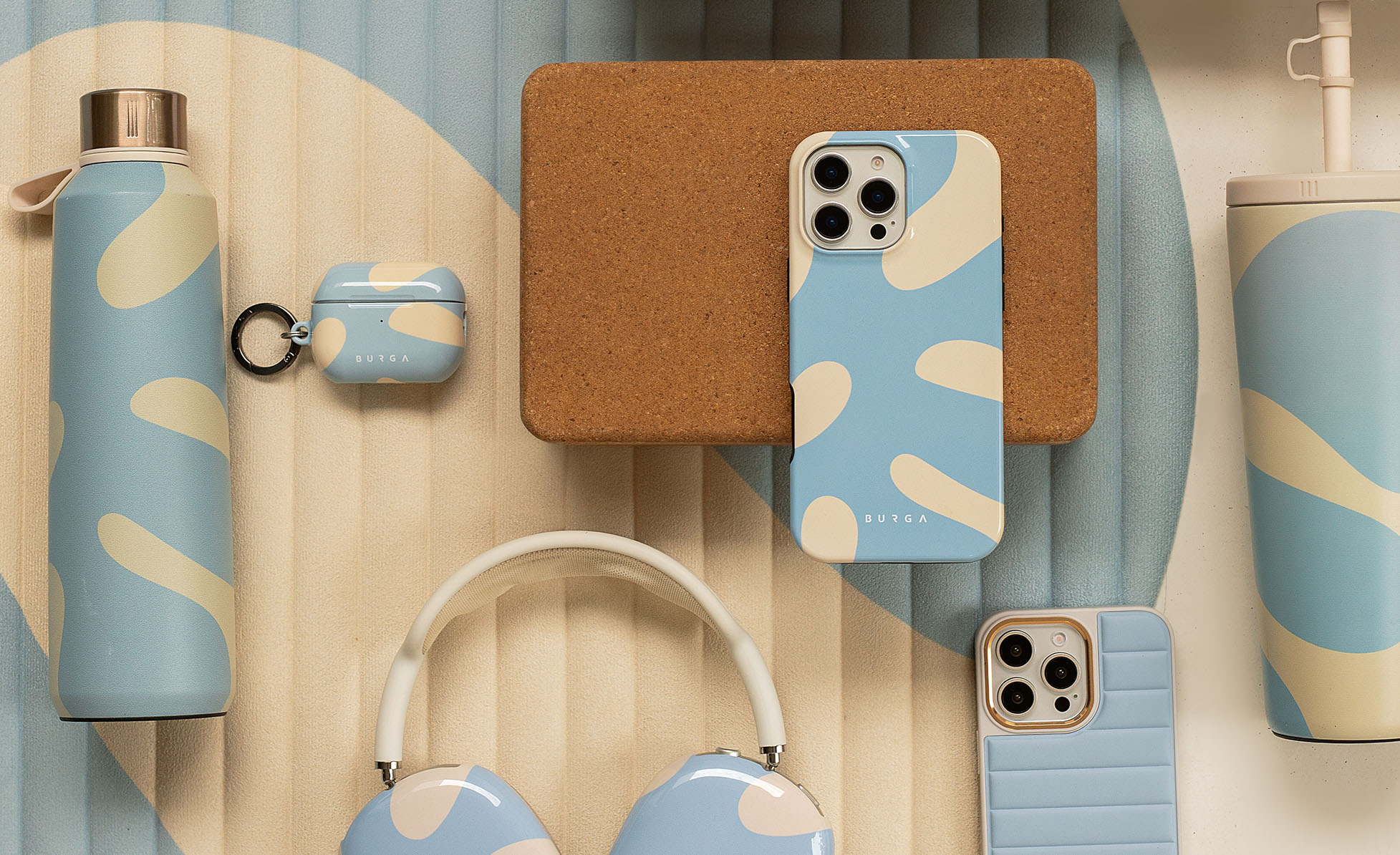 Assorted blue and beige accessories including phone cases, headphones, and bottles on a textured surface.
