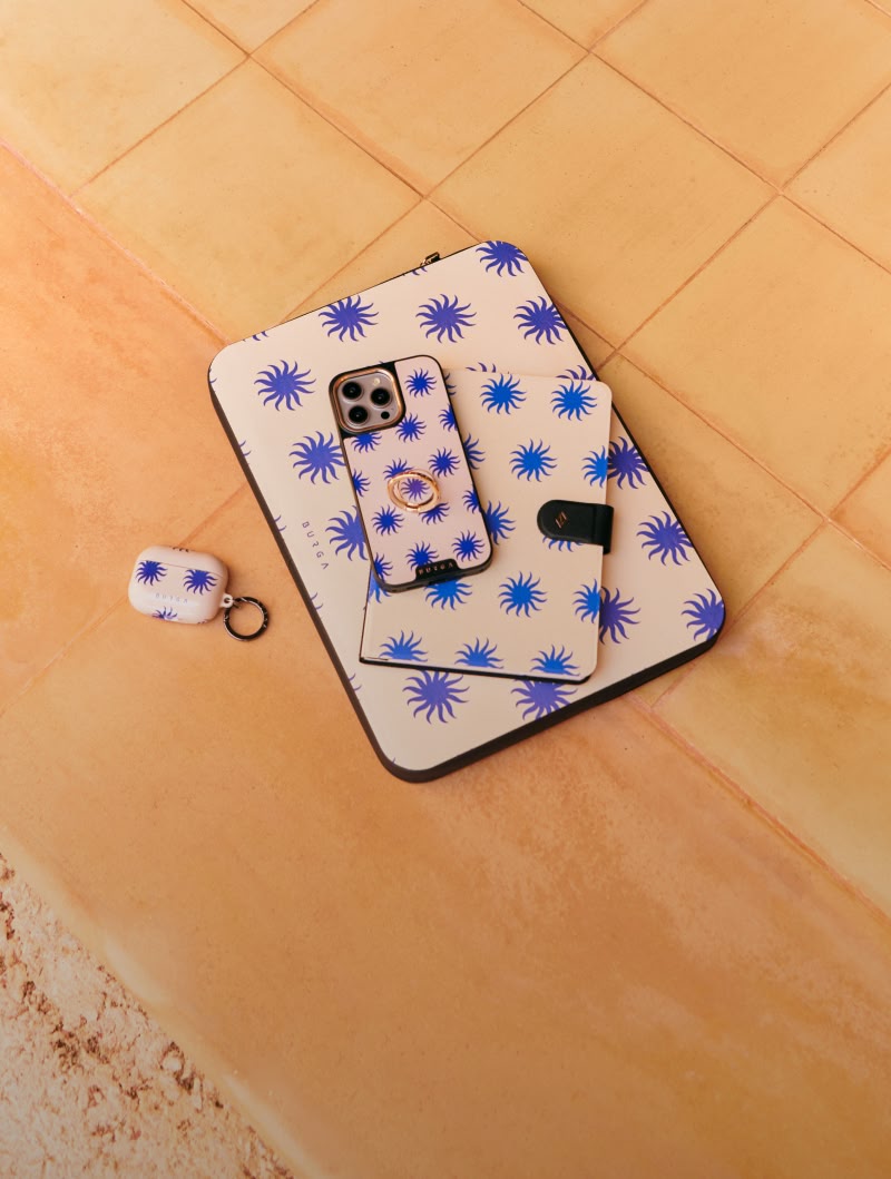 A collection of matching tech accessories with a blue sunburst pattern laid out on a tiled surface.
