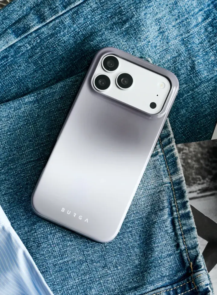 A smartphone in a purple-to-white gradient Burga case, resting on a pair of blue jeans.