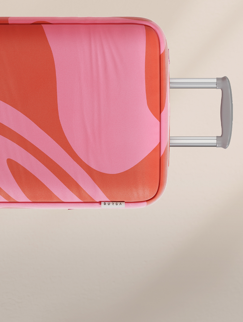 A close-up, top-down view of a pink and orange patterned suitcase with its handle partially extended.