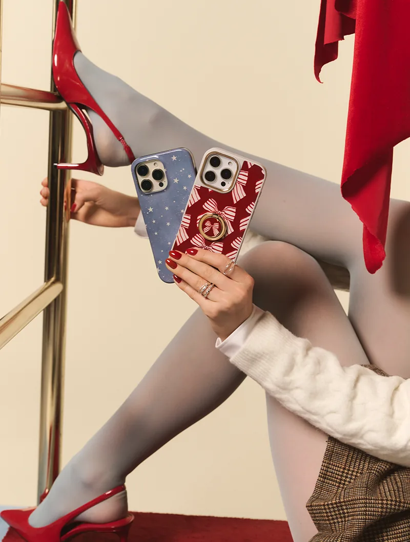 Red heels and two phone cases, a starry blue one and a red bow one with a ring holder