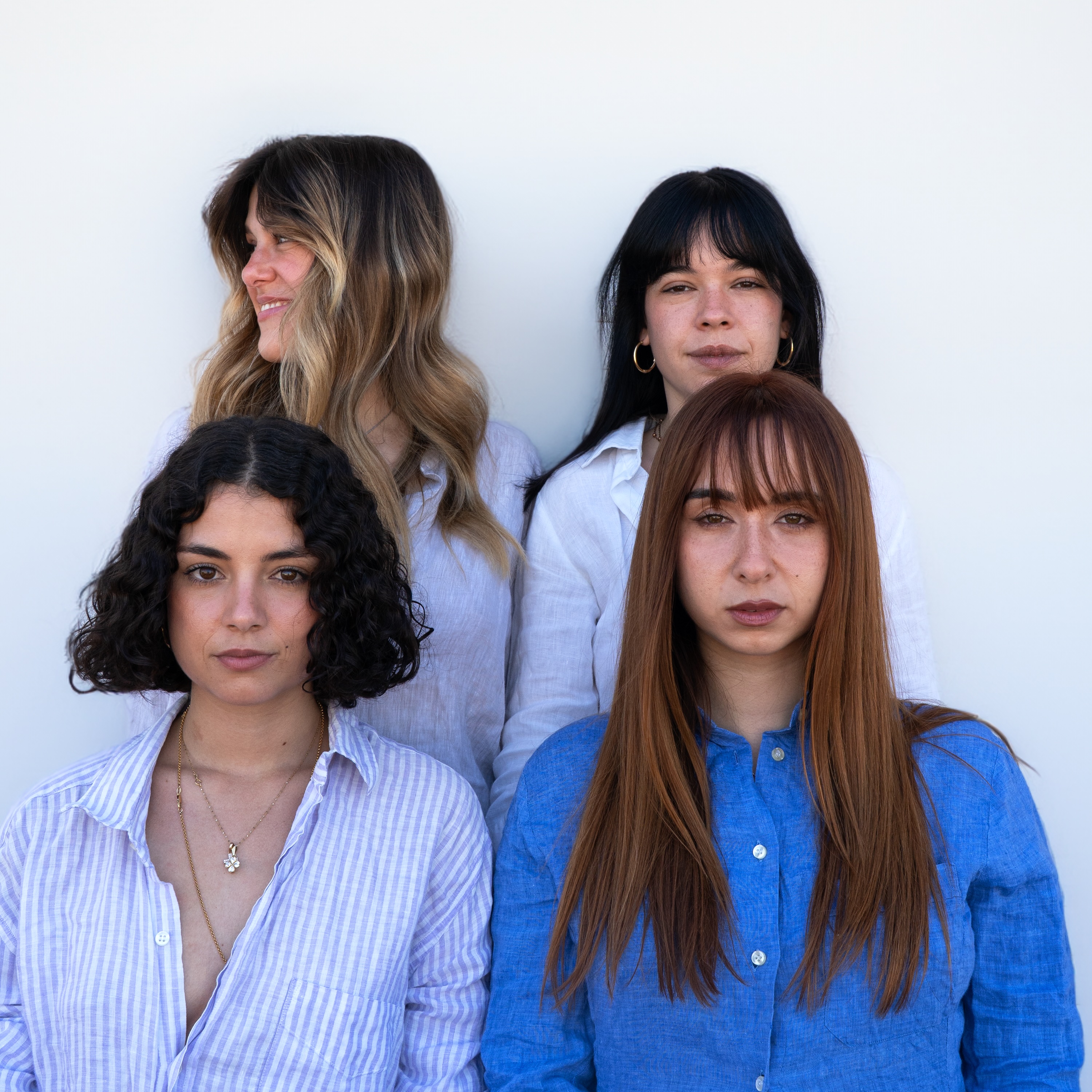 Quattro amiche sorridenti con diversi tipi di capelli, simbolo della diversità e dell'inclusività, che rappresentano l'ampia gamma di formule naturali Originae per ogni esigenza, senza sostanze chimiche aggressive.