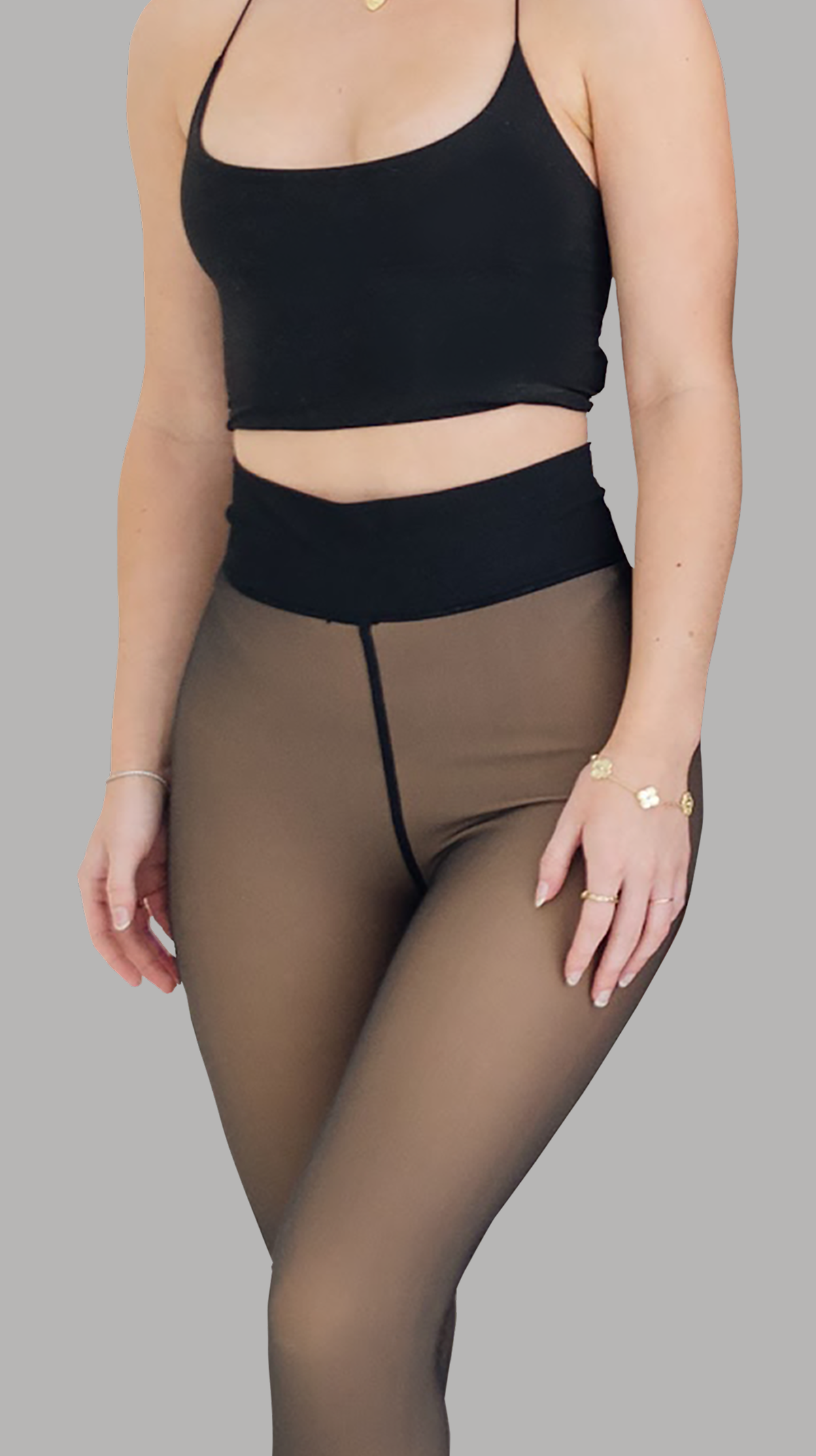 Person wearing a black crop top and sheer leggings.
