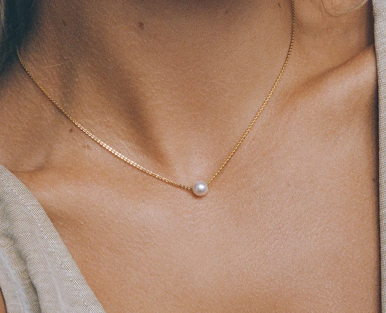 Close-up of a pearl necklace on a woman's neck.