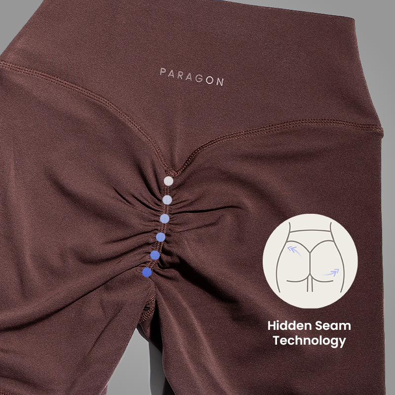 A close-up of the back of brown leggings showing the ruched seam and 'Hidden Seam Technology' graphic.