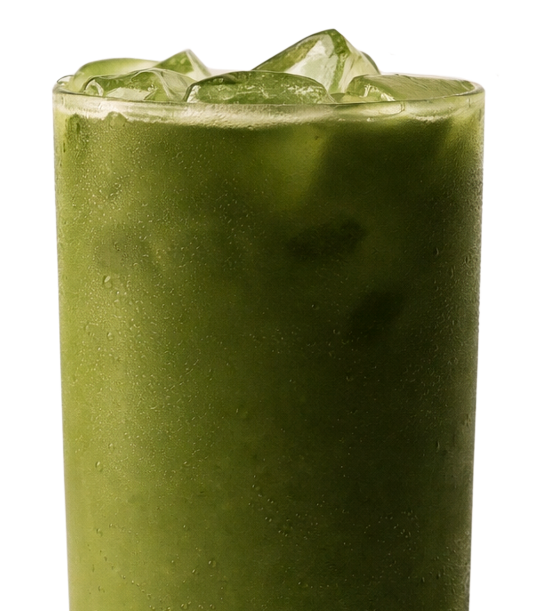 A close-up of a tall glass of an iced green beverage, with condensation on the glass.
