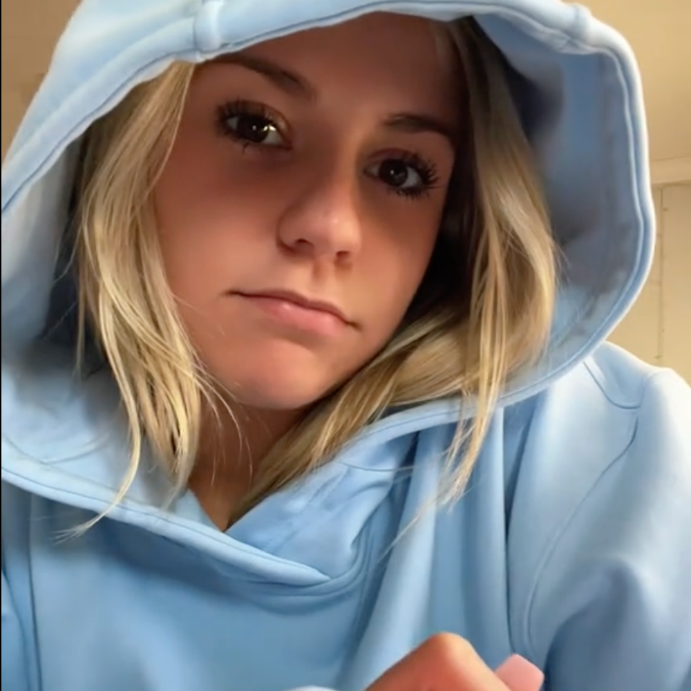 Person in a blue hoodie looking at the camera.