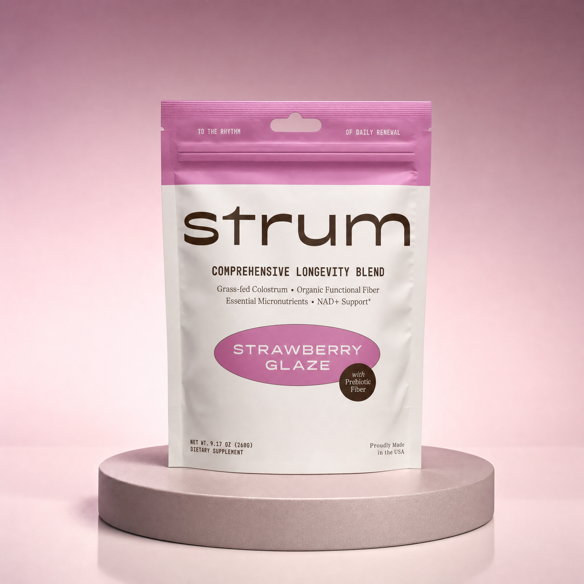 A pouch of Strum Strawberry Glaze Longevity Blend dietary supplement sitting on a pink pedestal.
