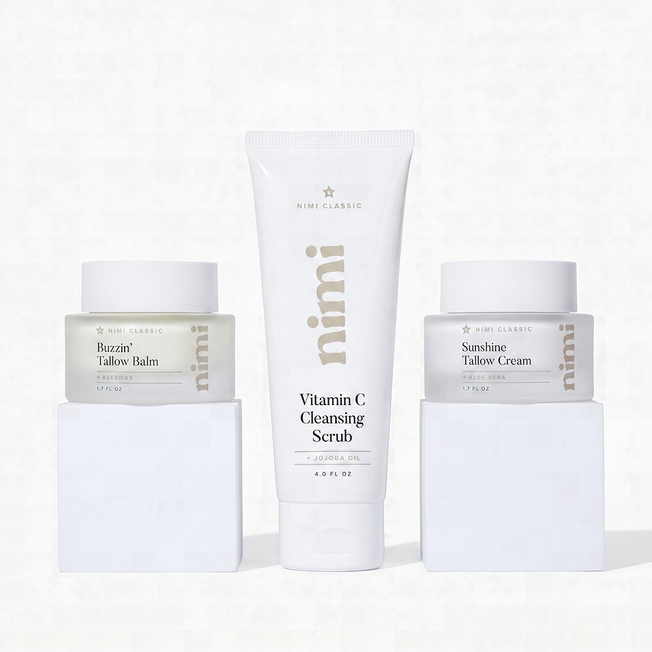 Three Nimi Classic skincare products, a scrub and two creams, displayed on white blocks against a white background.