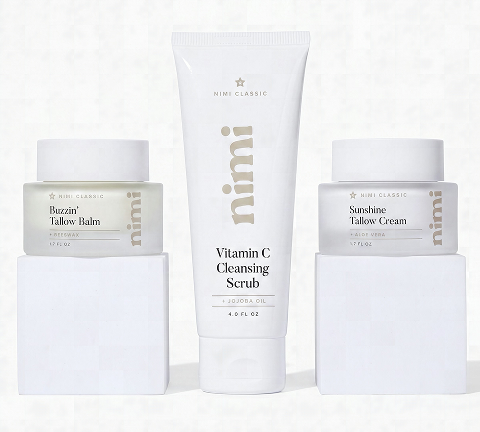 A set of three Nimi skincare products: a scrub, balm, and cream, displayed on white blocks.