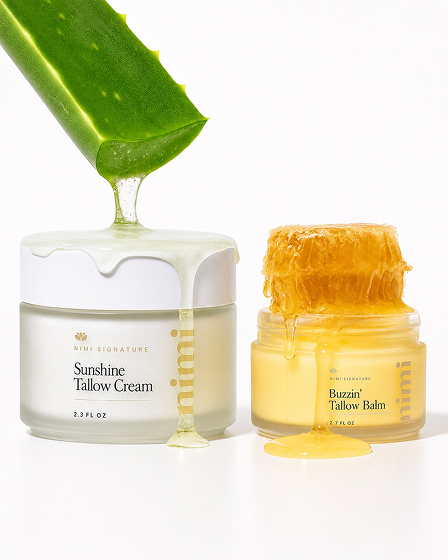 Two jars of tallow cream and balm with aloe and honeycomb dripping on them.