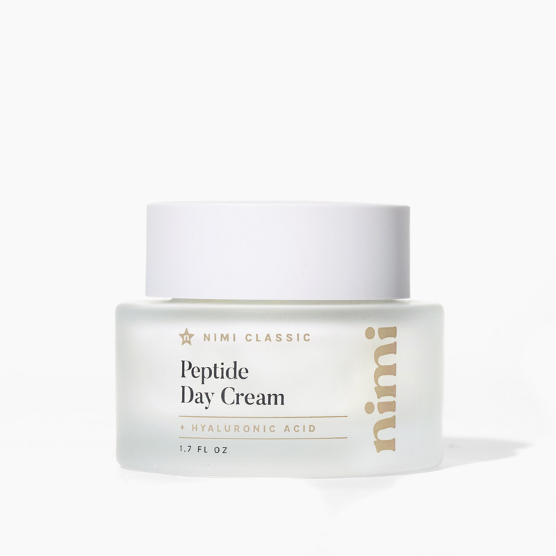 A frosted glass jar of Nimi Classic Peptide Day Cream with a white lid on a white background.