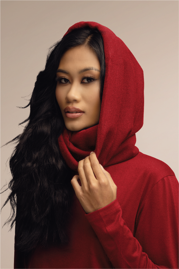 Person wearing a red scarf with long wavy hair, looking at the camera.