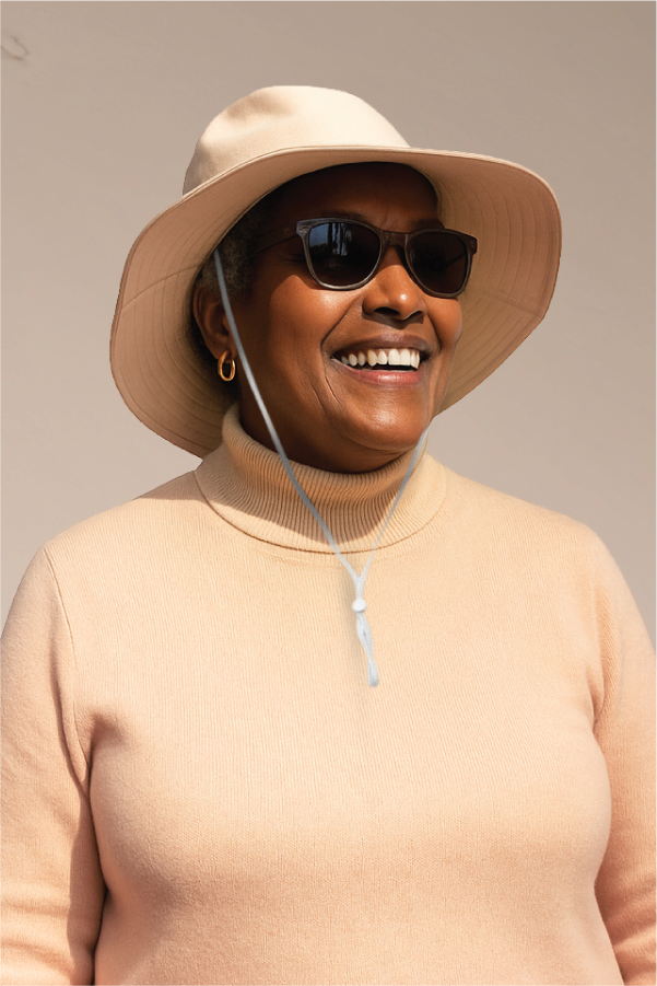 Smiling person wearing sunglasses and a wide-brimmed hat.